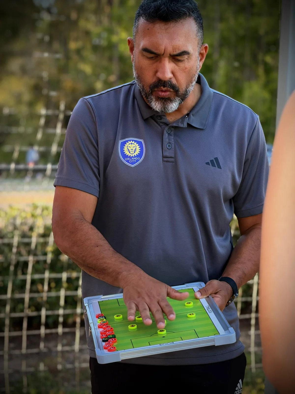Coach explaining soccer tactics with a magnetic field board