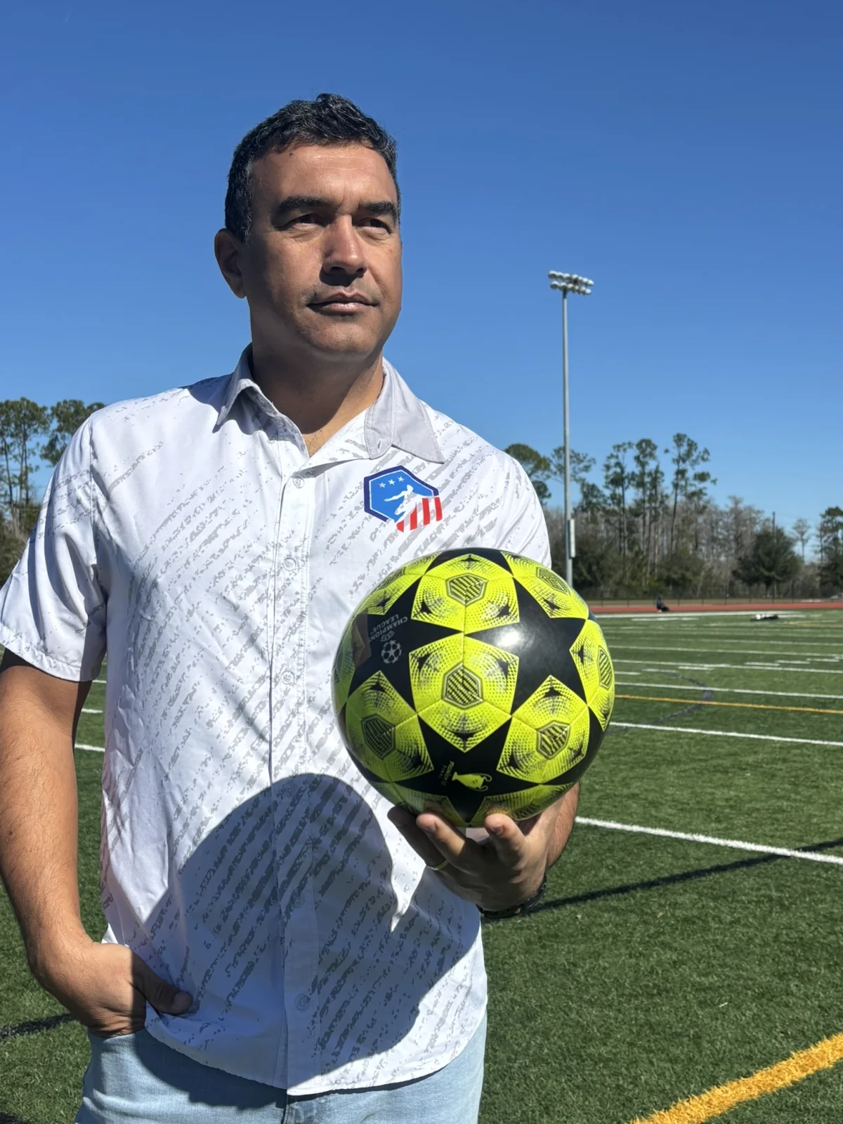 Soccer Training coach holding a soccer ball on the field
